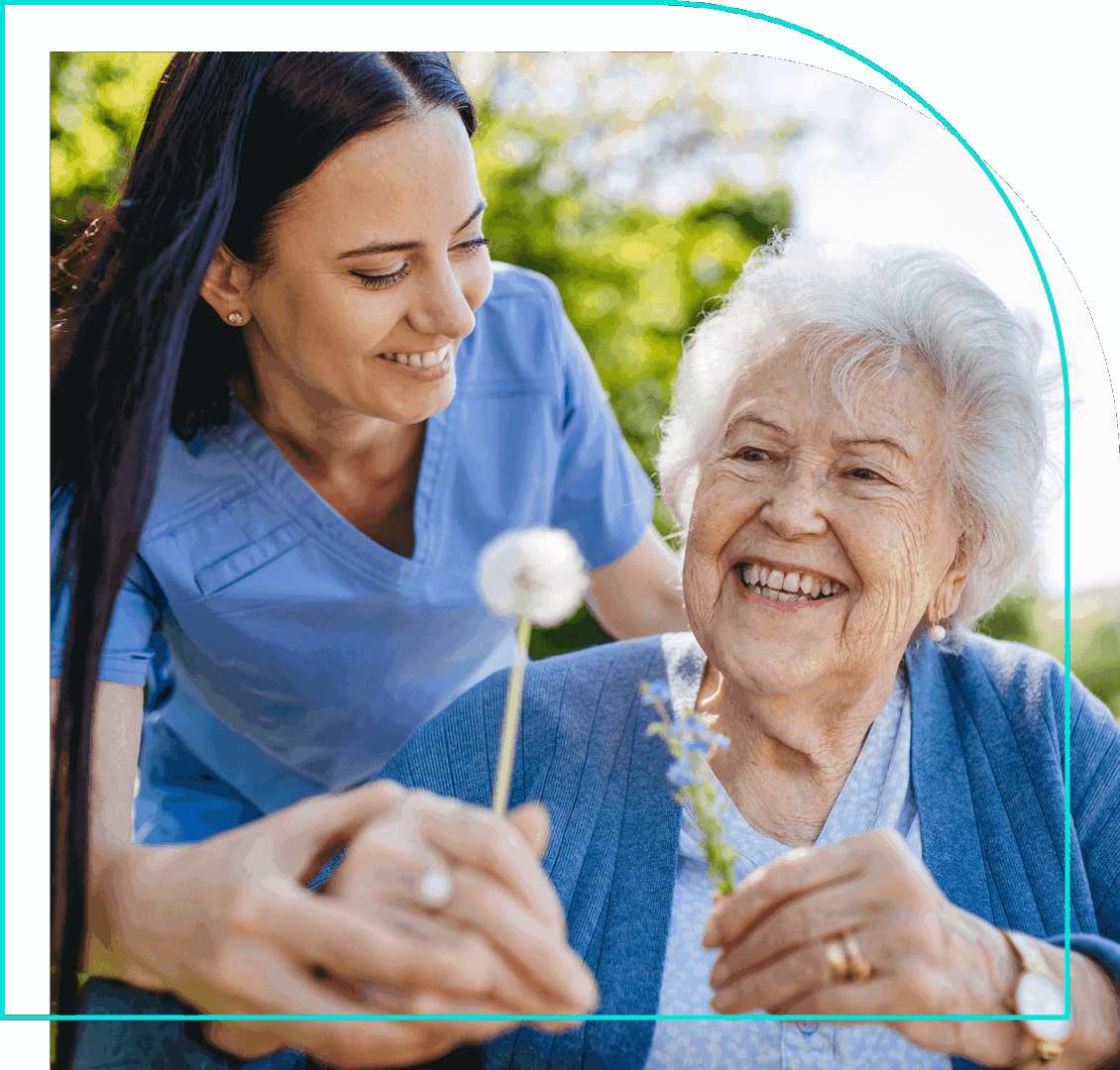 A woman and an elderly person holding a dandelion.